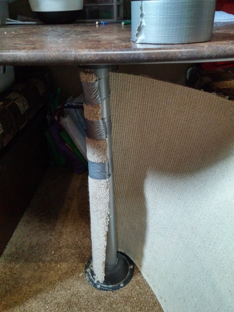 First, tape the carpet to the table leg